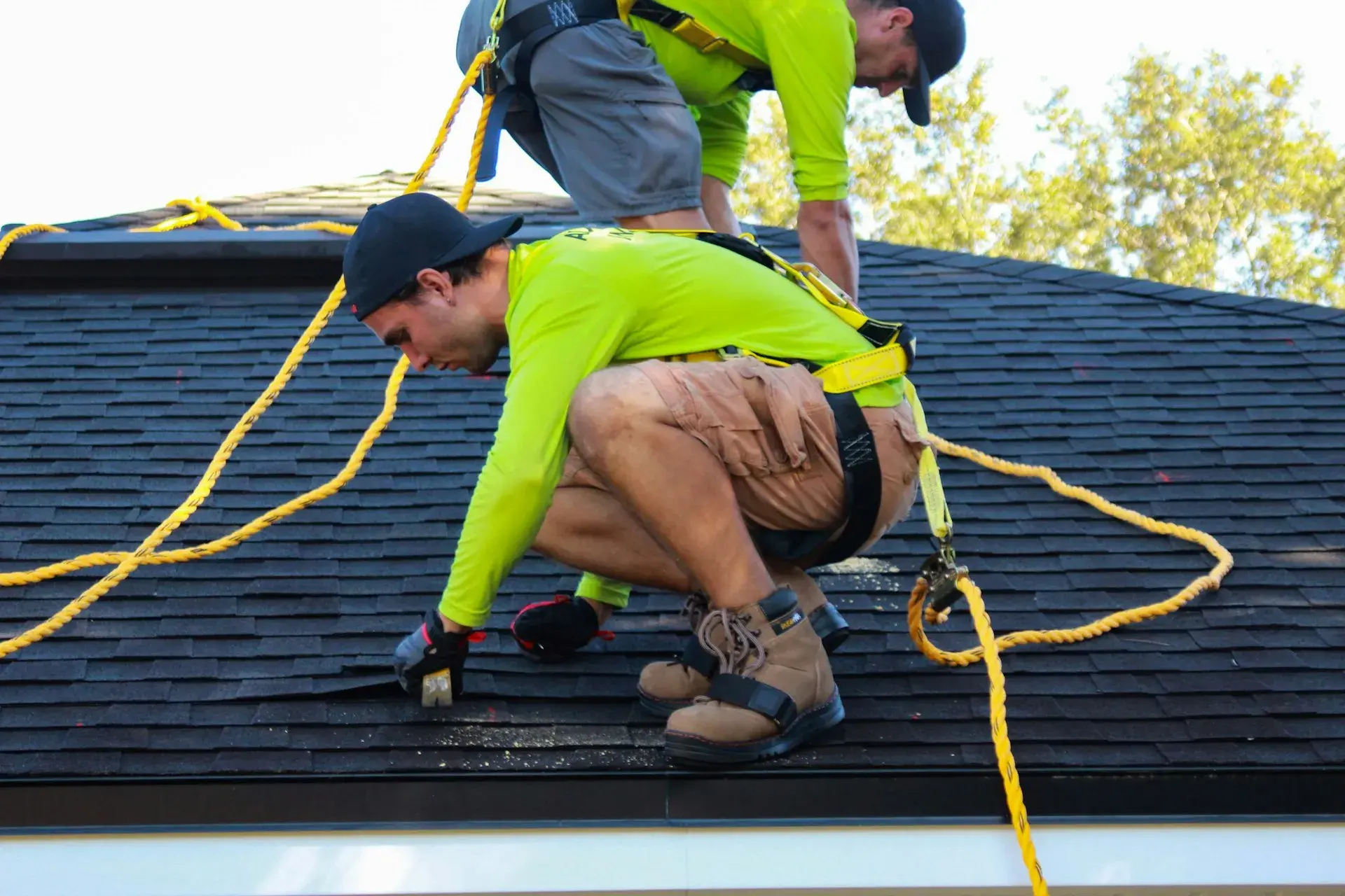 Roofing crew installing shingles on a home