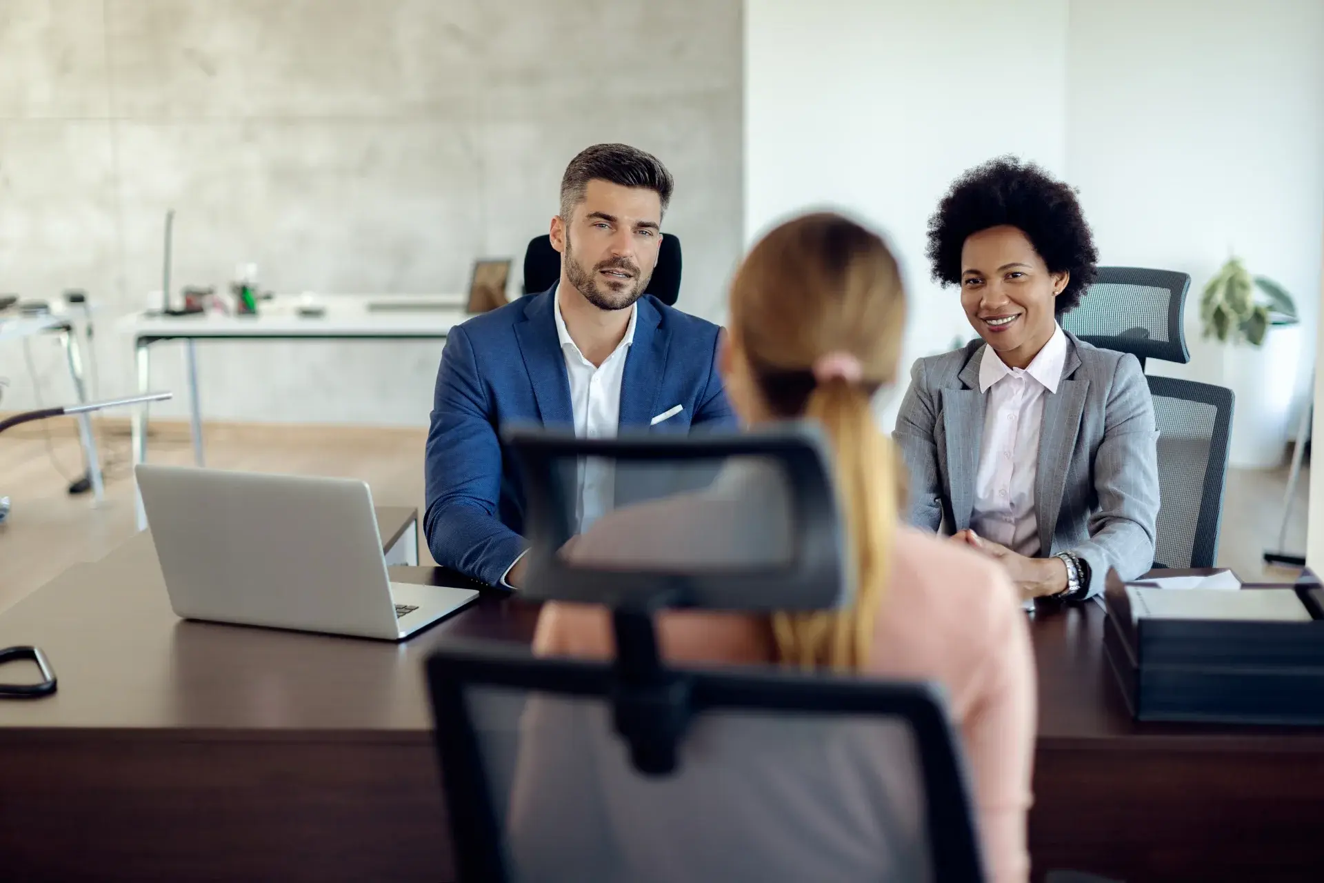 Employer and recruitment professionals interviewing a job candidate in an office