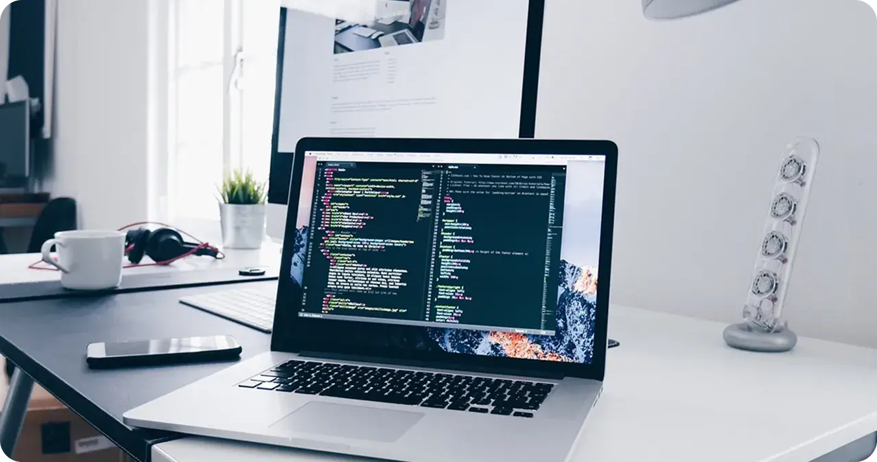 Laptop showing source code on a developer's desk