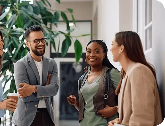 Three colleagues chatting over coffee in an office Three colleagues chatting over coffee in an office