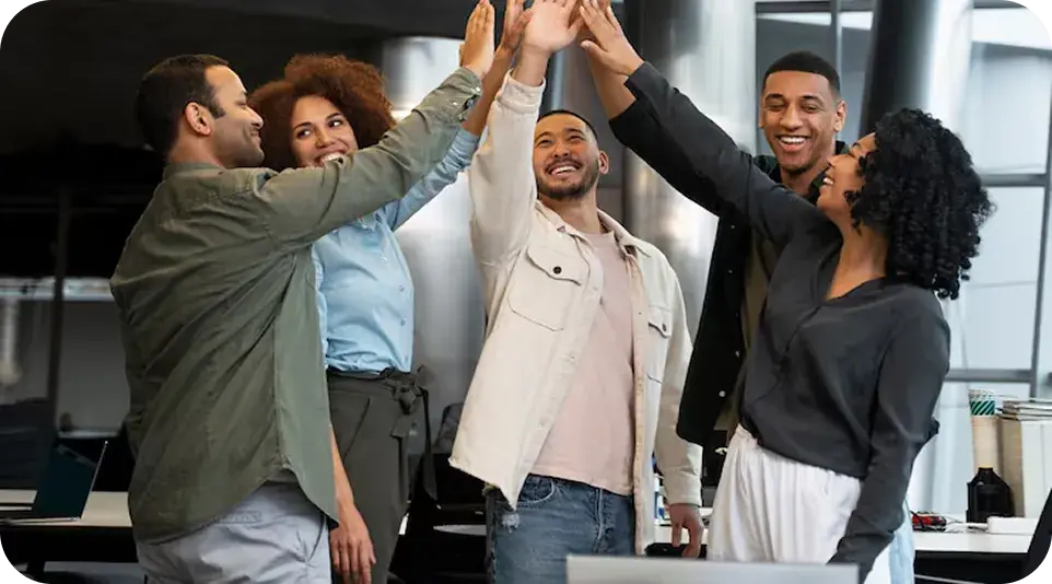 Coworkers celebrating a win with a high five in the office Coworkers celebrating a win with a high five in the office